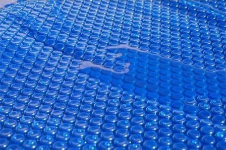 cubierta isotérmica flotando en el agua de la piscina